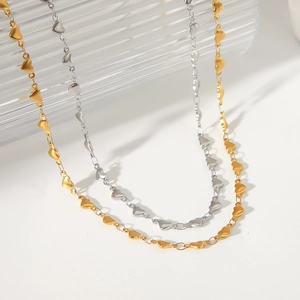 Detailed shot of interconnected gold and silver heart-shaped chain links in 18K finish