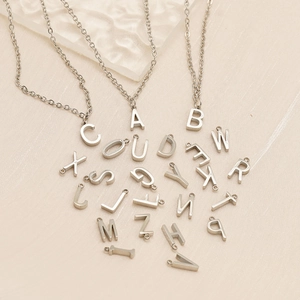 Silver 26 letters stainless steel pendant necklaces set displayed on fabric background