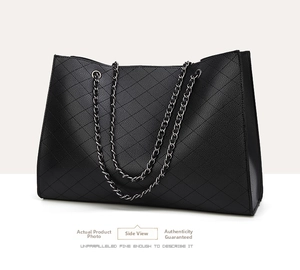 Side view of black quilted leather tote bag featuring elegant silver metal chain strap