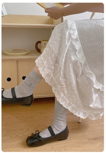 Close-up of light grey ribbed socks with cherry embroidery paired with Mary Jane shoes