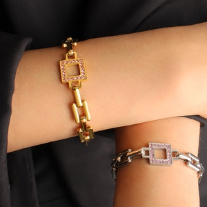 Detail of gold and silver square linked bracelets with pink cubic zirconia inlay