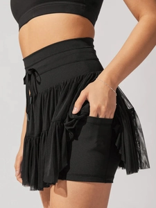 Detail view of black pleated tennis skirt with breathable mesh and functional side pocket