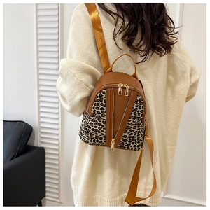 Rear view of model wearing a brown backpack with stylish leopard print and gold zippers