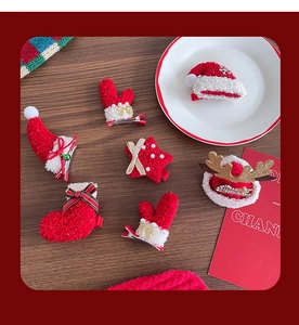 Detailed view of plush Christmas hair clips with Santa hat and reindeer antler designs