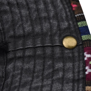 Detail of washed cotton canvas fabric with colorful ethnic embroidery and bronze snap button