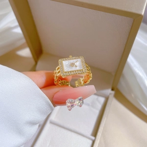 Gold watch-shaped adjustable ring with white zircon stones on a soft jewelry box