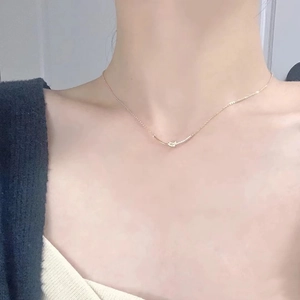 Elegant gold S925 sterling silver bow knot necklace worn by model in soft natural light