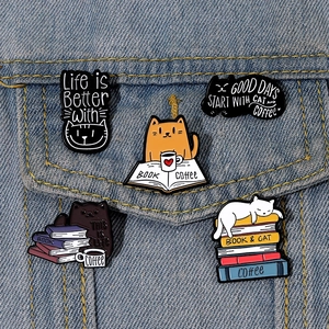 Detail shot of cute cat enamel pins on denim jacket showing vibrant craftsmanship