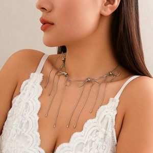 Detail of silver bowknot choker necklace with long tassel chains on a model
