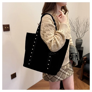 Shoulder view of black rivet tote bag with suede texture for stylish commuting