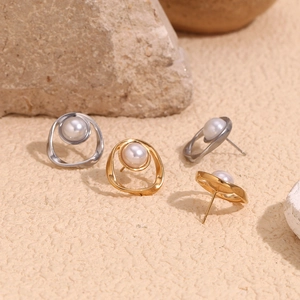 Macro shot of 18K gold and silver earrings with irregular rings and white pearls