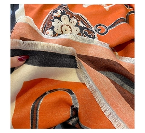 Detail of woven khaki cashmere scarf with vibrant pattern and fringe edges