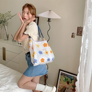 Close-up of floral pattern and brand logo on a large canvas tote bag with drawstring