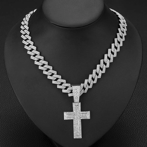 Close-up of hip hop silver Cuban chain necklace with a large iced-out diamond cross pendant