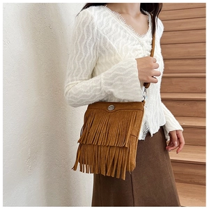 Brown suede crossbody bag with double-layer tassel detail shown on a female model