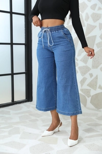 Détail d'un jean large bleu avec taille élastique à cordon de serrage et poches latérales