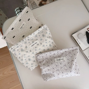 Close-up of floral print cotton makeup bags with simple wish label and metal zipper detail