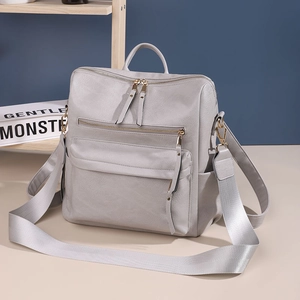 Nahaufnahme eines grauen Vintage-Rucksacks mit silbernen Reißverschlüssen und Textur