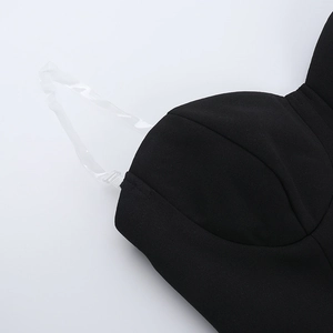 Close-up of detachable clear straps and stitching on a black tube dress