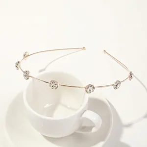 Detail showing gold leaf headband with sparkling rhinestones on a white ceramic cup