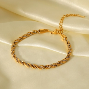 Bracelet de cheville tressé bicolore en acier inoxydable sur fond soie beige