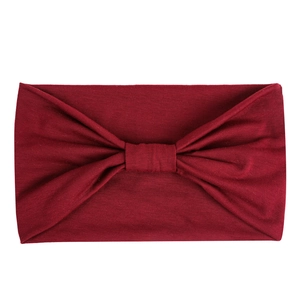 Detail showing burgundy stretch headband with twisted knot texture and soft knit fabric