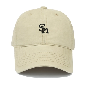 Close-up of SH letter embroidery and cotton canvas texture on a beige baseball cap