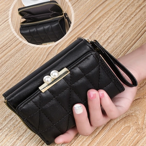 Close-up of quilted black wallet with pearl accents and triple accordion compartments