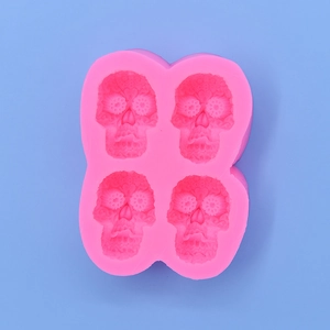 Stampo in silicone rosa con 4 teschi per dolci e fai-da-te su sfondo azzurro chiaro