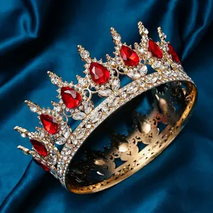 Golden crown with white rhinestones and red teardrop gems on blue silk fabric
