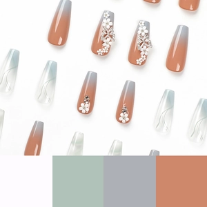 Press-on nails featuring orange-grey gradient, blue swirls, white flowers and butterflies