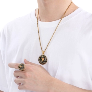 Gros plan sur l'ensemble collier et bague dorés avec gravure religieuse de l'armure de Dieu