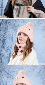 Detail of pink knitted winter beanie with faux fur pom and button neck warmer set