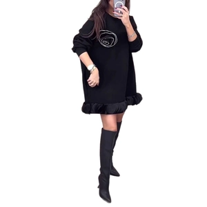 Détail de l'imprimé rose blanche et de l'ourlet à volants sur robe courte noire