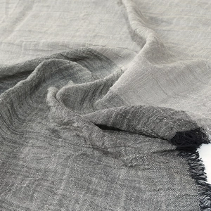Detailed macro view of grey gradient linen blend scarf texture with fringed edges