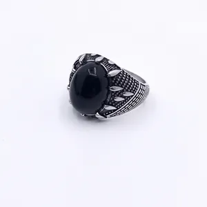 Detailed macro view of vintage titanium steel ring with oval black gemstone and textured band