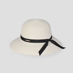 Detailed view of beige straw hat featuring fine weave texture and black ribbon bow detail
