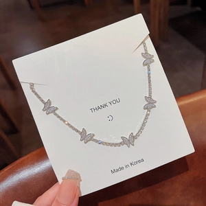 Détail du collier papillon en argent avec cristaux brillants sur support bijoux