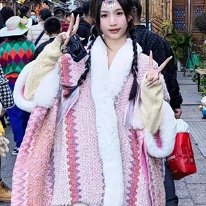 Outdoor street view of a pink knitted poncho shawl featuring a faux rabbit fur collar