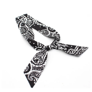 Detailed view of a black and white paisley pattern bow headband with soft fabric texture