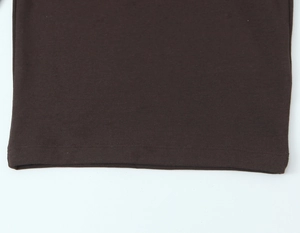 Gros plan détaillé de l'ourlet à double couture d'un t-shirt marron à manches longues