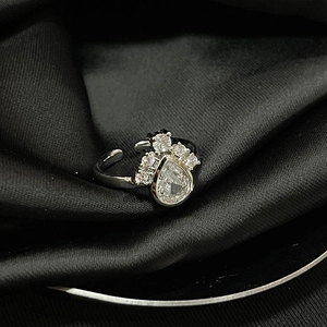 Macro shot of silver adjustable eye-shaped ring with teardrop zircons on black silk
