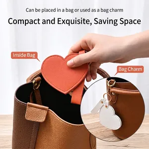 Portable heart-shaped leather vanity mirror and keychain charm in orange and white colors