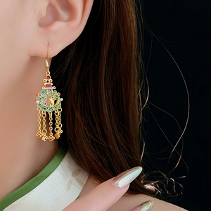 Détail des boucles d'oreilles cœur en or 18K avec émail coloré, perles et glands longs