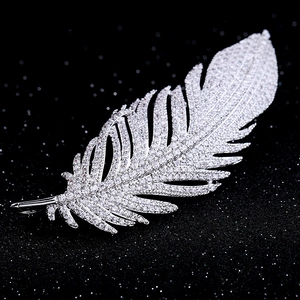 Detailed macro view of silver feather brooch with sparkling clear cubic zirconia crystals