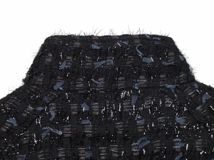 Macro shot of black tweed fabric with blue lace stripes and silver metallic threads