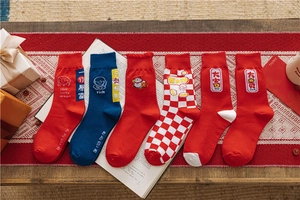 Detail of red and blue festive cotton socks with lucky embroidery and patterns