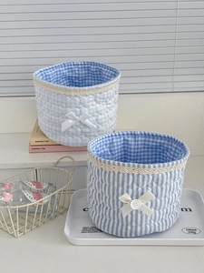 Detail of blue quilted lace storage bins with heart textures and ribbon bow details