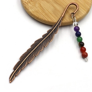 Detailed close-up of antique bronze feather bookmark with seven colorful crystal beads