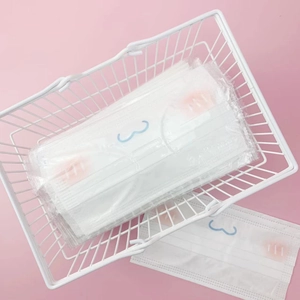 White iron mesh basket storing cute disposable masks with pink blush pattern designs